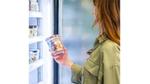 A women standing at a freezer cabinet holding a tub of Ben & Jerry’s ‘Karamel Sutra Core’ ice cream.