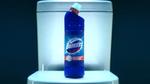 A bottle of blue Domestos on top of a white toilet